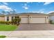 Tan house with three-car garage and landscaped yard at 2737 Nature View Rd, St Cloud, FL 34771