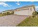 Tan house with three-car garage and manicured landscaping at 2737 Nature View Rd, St Cloud, FL 34771