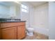 Clean bathroom with wood cabinets, granite countertop, and a bathtub at 2746 Stanwood Dr, Kissimmee, FL 34743