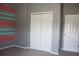A calming bedroom with striped walls features a large closet and a white door to hall at 515 Haywood Ln, Lake Alfred, FL 33850
