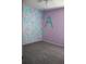 Bedroom features unique geometric wall art, a large letter on a pastel-painted wall, and a ceiling fan at 515 Haywood Ln, Lake Alfred, FL 33850