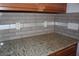 Granite countertop with a neutral tile backsplash at 515 Haywood Ln, Lake Alfred, FL 33850