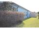 Side view of house with bushes, lush green lawn, and white fence at 515 Haywood Ln, Lake Alfred, FL 33850