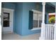 View of the front porch of bright blue home with white railings and door at 515 Haywood Ln, Lake Alfred, FL 33850