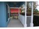 Covered front porch with white railings, columns, and bushes at 515 Haywood Ln, Lake Alfred, FL 33850
