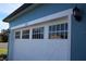 View of the exterior two car garage, painted white with decorative windows at 515 Haywood Ln, Lake Alfred, FL 33850