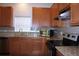 A kitchen with wood cabinets, granite countertops, tile backsplash, and stainless steel appliances at 515 Haywood Ln, Lake Alfred, FL 33850
