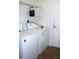 A modern laundry room includes white washer and dryer, shelving, and vinyl flooring at 515 Haywood Ln, Lake Alfred, FL 33850