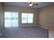 View of a neutral-toned living room featuring plush carpet and large sliding glass doors at 515 Haywood Ln, Lake Alfred, FL 33850