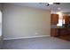 Open living area with neutral walls and carpet adjacent to kitchen with wood cabinets at 515 Haywood Ln, Lake Alfred, FL 33850