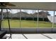 Screened patio with backyard view, ceiling fan, and room for outdoor furniture at 515 Haywood Ln, Lake Alfred, FL 33850