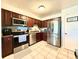 Well-equipped kitchen with stainless steel appliances and dark wood cabinets at 5271 Whitstable Way # 1, Orlando, FL 32812
