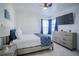 Bright bedroom with a queen bed, dresser, and large window at 8059 King Palm Cir, Kissimmee, FL 34747