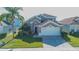 Two-story house with a neutral exterior, two-car garage, and manicured lawn at 8059 King Palm Cir, Kissimmee, FL 34747