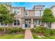 Tan two-story townhome with blue door, brick walkway, and landscaping at 8127 Cadman St, Orlando, FL 32832
