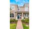 Tan two-story townhome with blue door, brick walkway, and landscaping at 8127 Cadman St, Orlando, FL 32832
