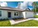 Newly built home showcasing a white exterior, a two-car garage, and a nicely landscaped front yard at 14 Guava Terrace Trak, Ocklawaha, FL 32179