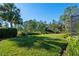 Landscaped backyard with lush green grass and palm trees at 1592 Lincolnshire Drive, Deland, FL 32724