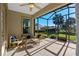 Relaxing screened porch with wicker furniture and backyard view at 1592 Lincolnshire Drive, Deland, FL 32724