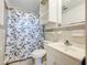 Functional bathroom with a leaf patterned shower curtain and white cabinets at 201 N East St, Leesburg, FL 34748