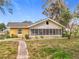 Charming one-story home with screened porch and mature trees in a residential neighborhood at 201 N East St, Leesburg, FL 34748