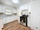 Spacious kitchen features white cabinets, a stainless steel oven, and a bright window overlooking the yard at 201 N East St, Leesburg, FL 34748