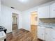 Bright kitchen featuring wood-look floors, white cabinets, and an open layout to the connecting room at 201 N East St, Leesburg, FL 34748