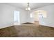Living room with tan carpet, white walls, chandelier, and open archway to dining area at 201 N East St, Leesburg, FL 34748