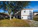 Two-story house with a two-car garage and mature tree in the front yard at 266 Vervain Ave, Davenport, FL 33837