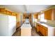 Kitchen with light wood cabinets, white appliances, and an island at 266 Vervain Ave, Davenport, FL 33837