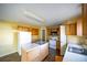 Kitchen with light wood cabinets, white appliances, and an island at 266 Vervain Ave, Davenport, FL 33837