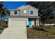 Two-story house with gray siding, a blue door, and a two-car garage at 2903 Travelers Palm Dr, Edgewater, FL 32141