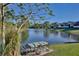 A picturesque backyard with a wrought iron bench overlooking a serene lake at 2981 Viscount Cir, Kissimmee, FL 34747