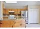 Well-lit kitchen features stainless steel appliances, an island, and light wood cabinets at 2981 Viscount Cir, Kissimmee, FL 34747