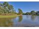 Scenic lake view with lush green landscaping and mature trees offering a serene and peaceful setting at 2981 Viscount Cir, Kissimmee, FL 34747