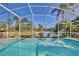 Screened pool offers stunning waterfront views of the lush landscaping and tranquil canal at 2981 Viscount Cir, Kissimmee, FL 34747