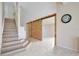 Stylish staircase and double sliding barn doors in the entryway at 2981 Viscount Cir, Kissimmee, FL 34747