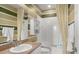 Bathroom with tub, shower and striped walls at 31921 Redtail Reserve Blvd, Sorrento, FL 32776