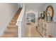 Bright entryway with staircase, tile floors, and light wood cabinet at 3428 Costello Cir, Winter Haven, FL 33884