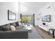 Living room with gray sectional sofa, balcony access, and a large TV at 3900 Southpointe Dr # 127, Orlando, FL 32822