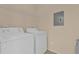 Bright laundry room with white washer and dryer, overhead wire rack, and light beige walls at 412 Summit Ridge Pl # 210, Longwood, FL 32779