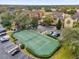 Overhead view of a tennis court with green fencing in a community near ample parking and mature trees at 412 Summit Ridge Pl # 210, Longwood, FL 32779