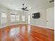 Spacious bedroom featuring hardwood floors, neutral decor, and natural light from the surrounding windows and doors at 4520 Old Carriage Trl, Oviedo, FL 32765