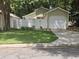 Light green house with white fence, garage, and well-manicured lawn at 513 Harvard Pl, Apopka, FL 32703