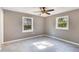 Bright bedroom with tile floors, ceiling fan, and two windows at 540 Fern Ave, Tavares, FL 32778