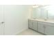 Modern bathroom with double vanity, light gray cabinets and a large mirror at 5701 Le Marin Way, Kissimmee, FL 34758