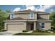 Two-story house with gray siding, brown door, and attached garage at 5701 Le Marin Way, Kissimmee, FL 34758