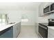 Modern kitchen with gray cabinets, stainless steel appliances, and white countertops at 5701 Le Marin Way, Kissimmee, FL 34758