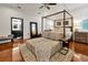 Main bedroom with four-poster bed, hardwood floors, and ensuite bathroom at 606 E Amelia St, Orlando, FL 32803