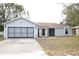 Gray house with attached garage and a spacious front yard at 741 Caribou Dr, Kissimmee, FL 34759